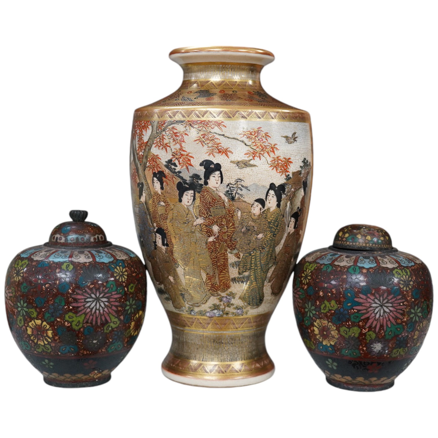 A pair of Japanese cloisonné enamel jars and covers, a Japanese bronze and gold overlaid small vase and a Satsuma pottery vase, tallest 22cm high (4). Condition - finial loose and one missing on cloisonné jars and covers